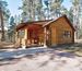 Cabin sits under pine trees in Blue Bell Lodge area at Custer State Park