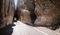 A narrow road tunnel that carves through huge granite boulders