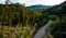 Aerial shot of a scenic road with hills and trees surrounding