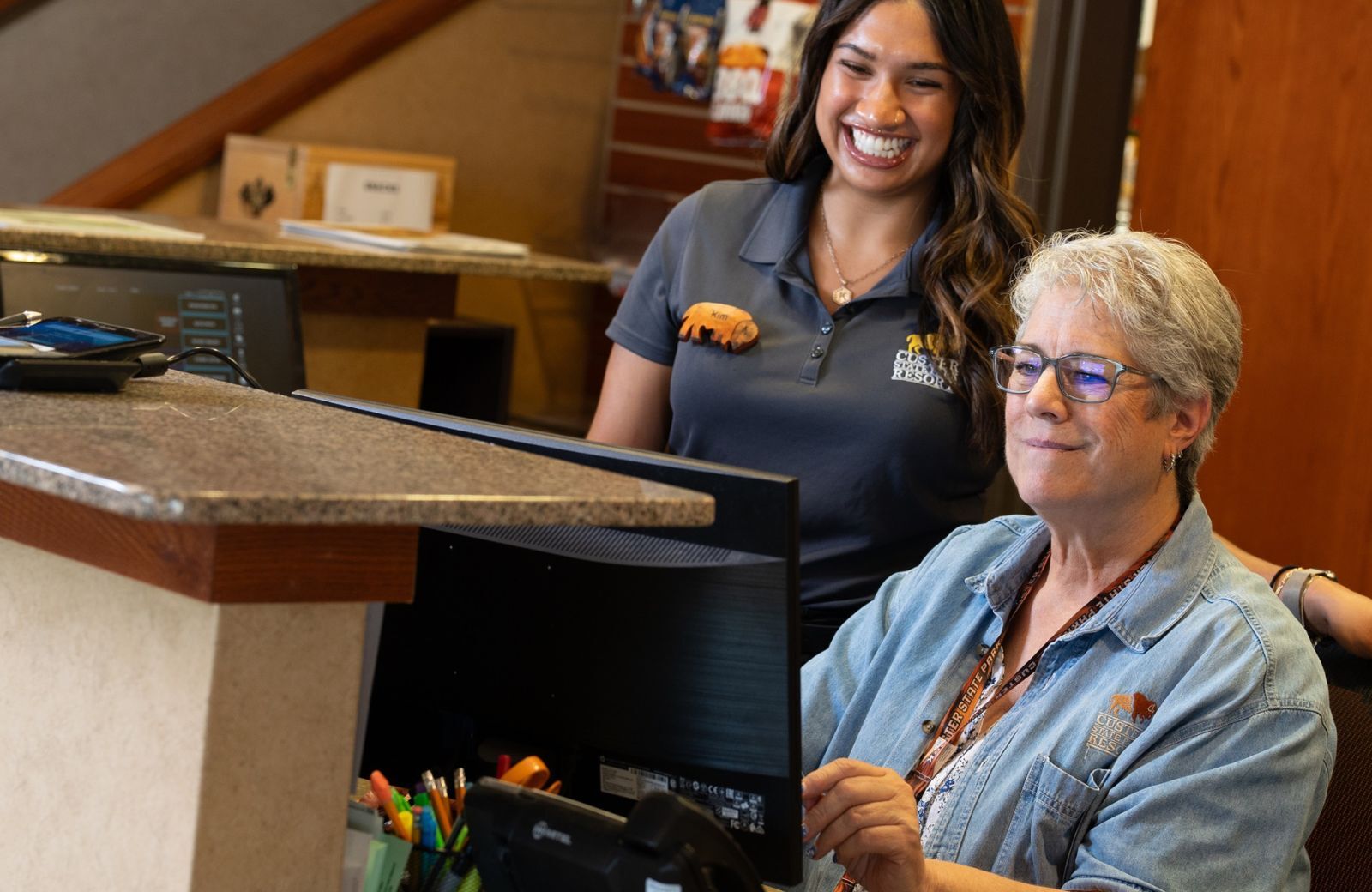 Two people smiling and looking at a computer screen