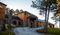 Exterior view of Sylvan Lake Lodge in Custer State Park, featuring rustic architecture with stone and wood siding. A curved driveway leads to the main entrance, surrounded by pine trees and well-kept grounds.