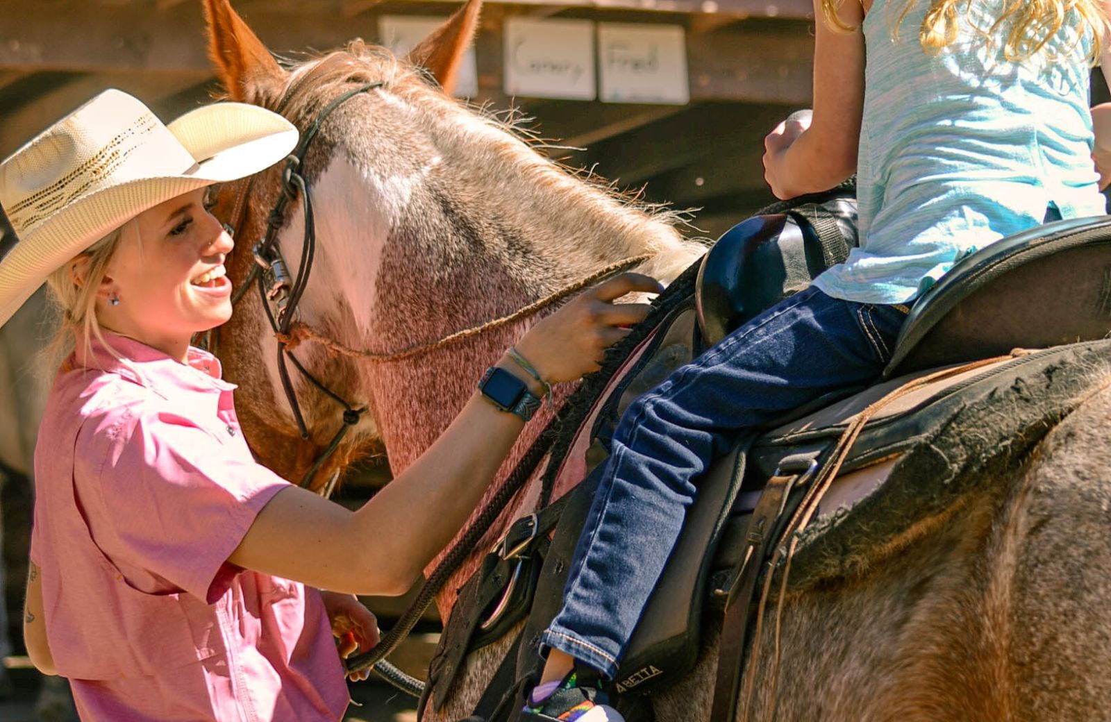 child riding a horse and person guiding them